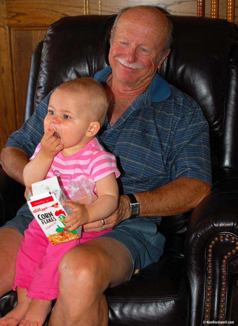 Katie eating corn flakes on Pops' lap