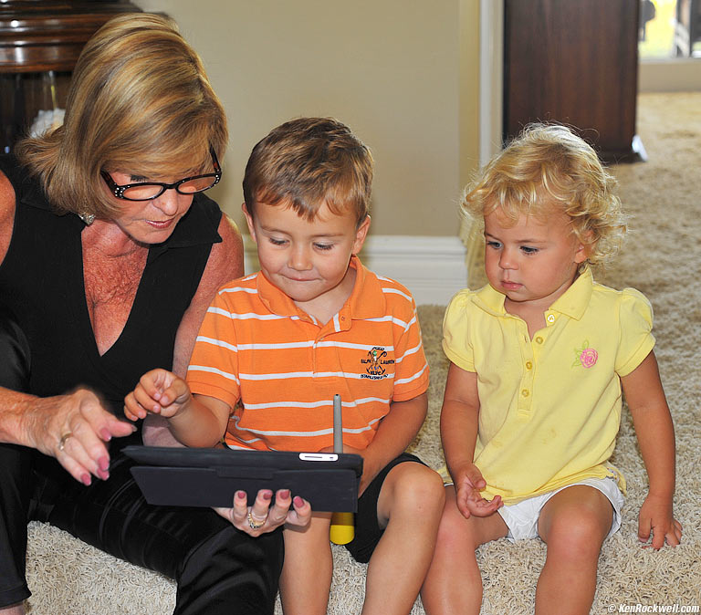 Noni shows the babies her iPad. 