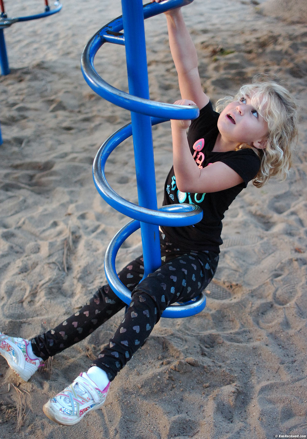 Katie climbs the curly-que at the park.