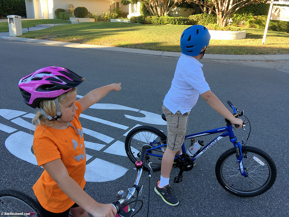 Kids riding bikes — and using hand signals to signal their turns