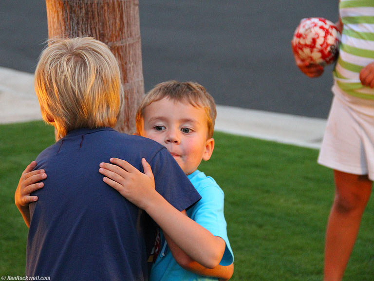 Ryan plays ball with two eight-year-olds, and gives one a hug, 7:13 PM. 